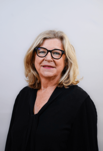 Porträtfoto einer Frau mit halblangen blonden Haaren und Brille.